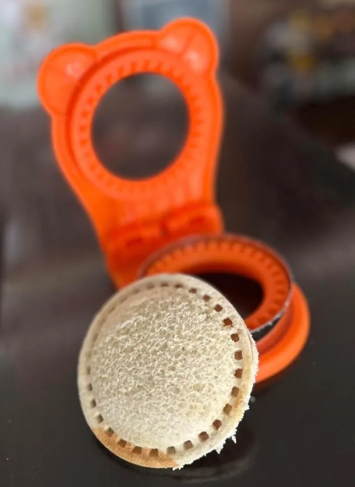 Orange kitchen gadget with a round sandwich cutter and shaped bread slice, showcasing Amazon most wished for weirdly wonderful items.