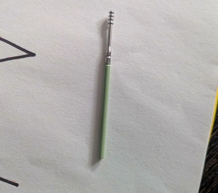 Small mystery object with a green handle and metal screw-like top shared in online group to help recognize items