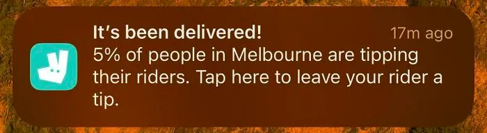 Notification from a delivery app showing a prompt about tipping riders, illustrating ridiculous tipping culture trends.