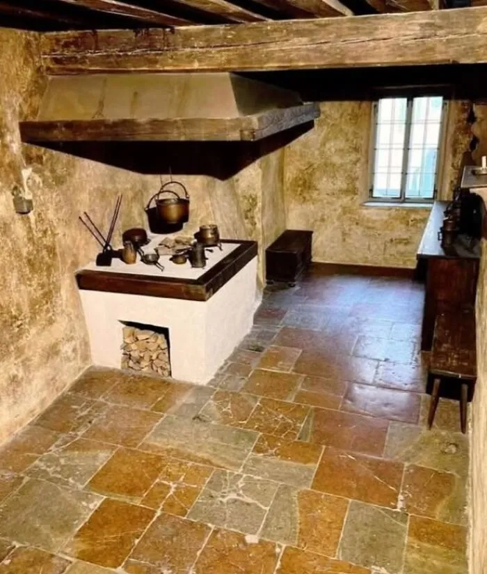 Cocina arqueológica con utensilios antiguos y horno de leña, representando increíbles descubrimientos arqueológicos educativos.