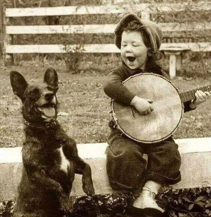 A Young Boy Playing The Banjo With His Best Friend In The Early 1900s