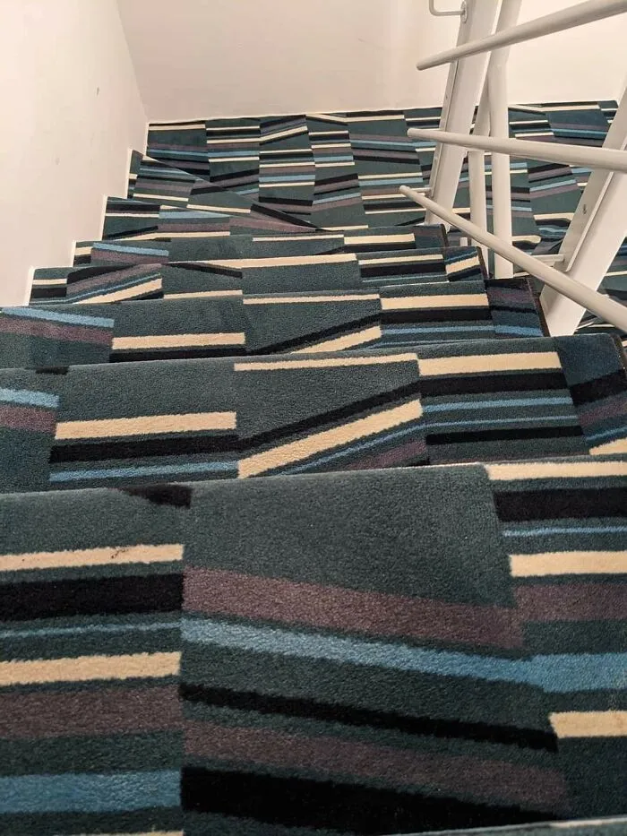 A Set Of Stairs Going Down With A Metal Handrail