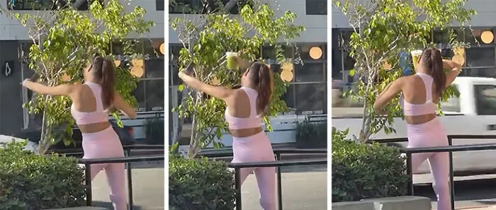 Influencer en ropa deportiva rosa realizando actividad física frente a un edificio, mostrando actitud despreocupada.