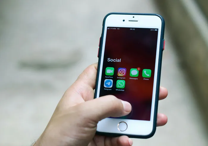 Hand holding smartphone displaying social media apps like Instagram and WhatsApp, illustrating biggest mistake of their lives concept.