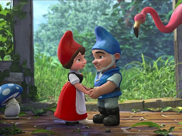 Two animated garden gnomes holding hands outdoors with a flamingo and mushroom nearby, symbolizing twins and pregnancy.