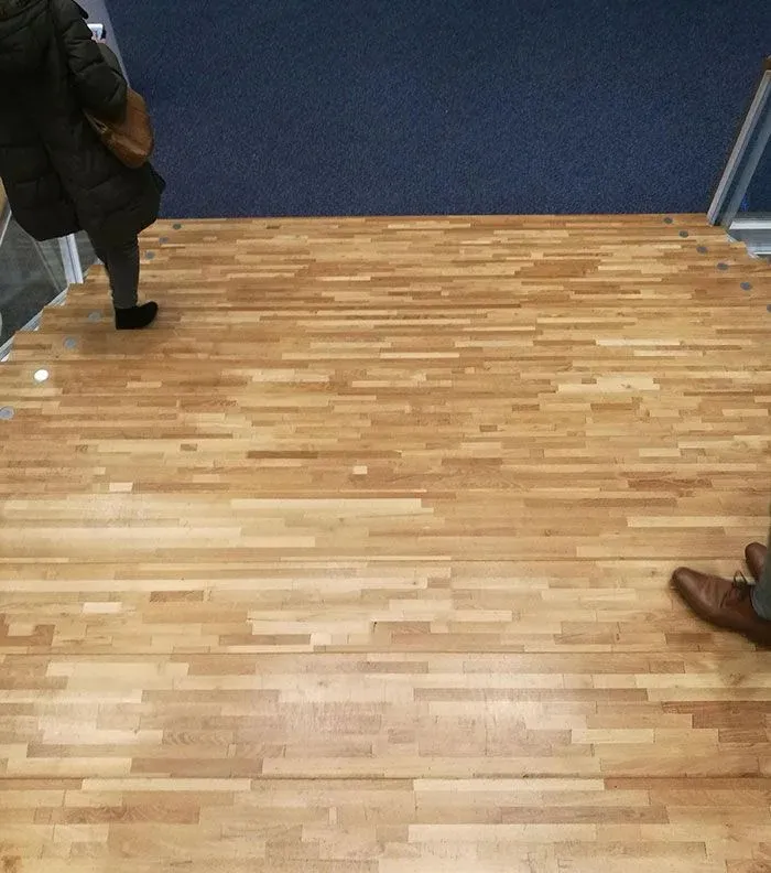 A View Down A Flight Of Stairs Made Of Some Sort Of Wooden Parquet
