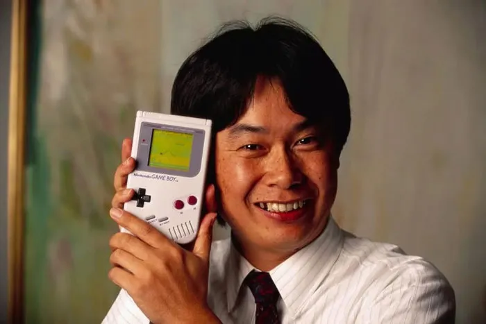 Shigeru Miyamoto, creador de Mario y otros personajes y videojuegos para Nintendo, sostiene una Game Boy de Nintendo con el videojuego Super Mario World. Junio ​​de 1992.