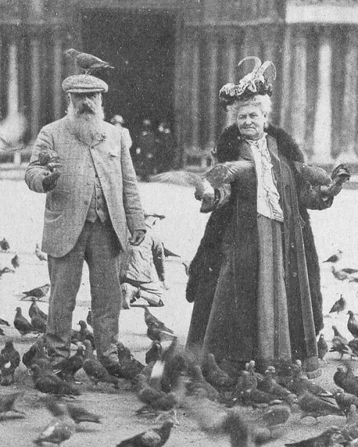 Vintage photo of a man and woman feeding pigeons, illustrating weird things about history from an Instagram account.
