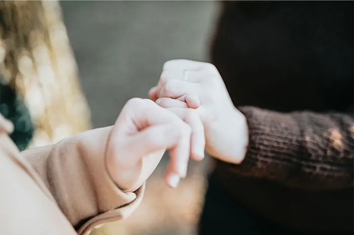 Close-up of two people holding hands outdoors, illustrating relationship icks and communication issues with cats.