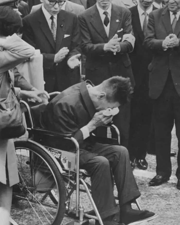 Man in wheelchair wiping tears while others in suits clap, illustrating surprise and emotion in weird history facts.