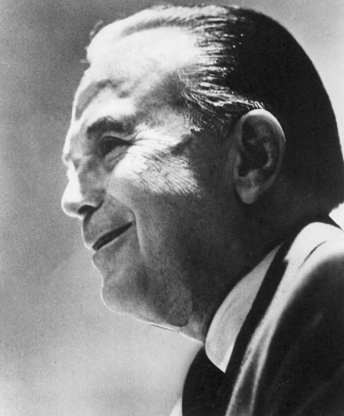 Black and white profile of a late bloomer millionaire smiling confidently, symbolizing success after being counted out.