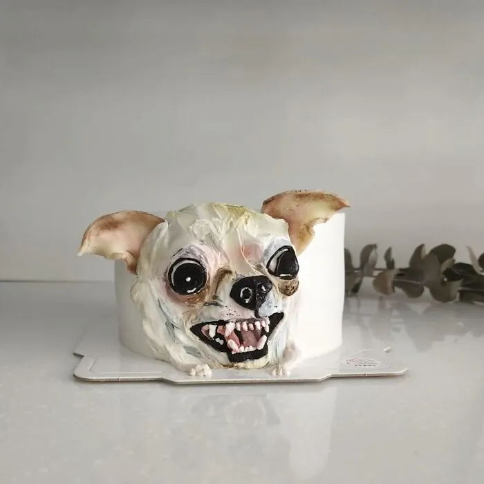 Pet-themed cake shaped like a small dog with detailed facial features capturing its unique personality.