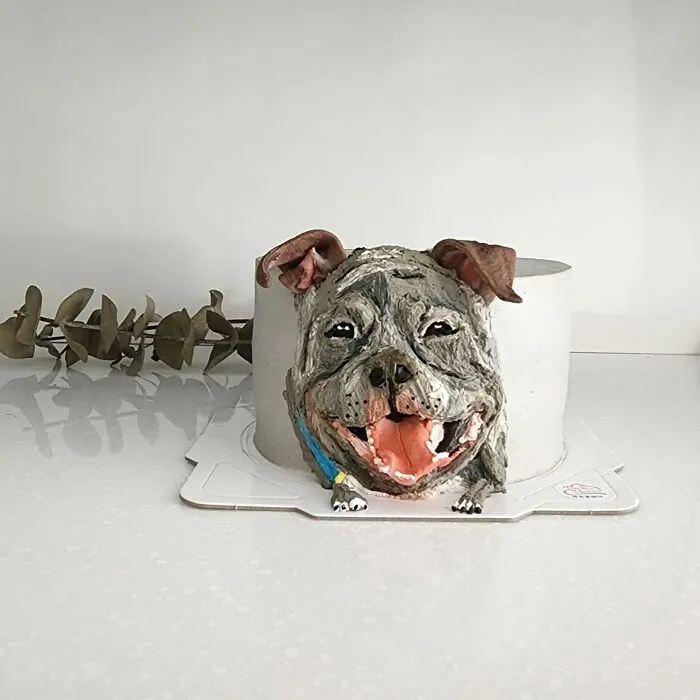 Adorable pet-themed cake shaped like a happy dog capturing its unique personality on a white surface.