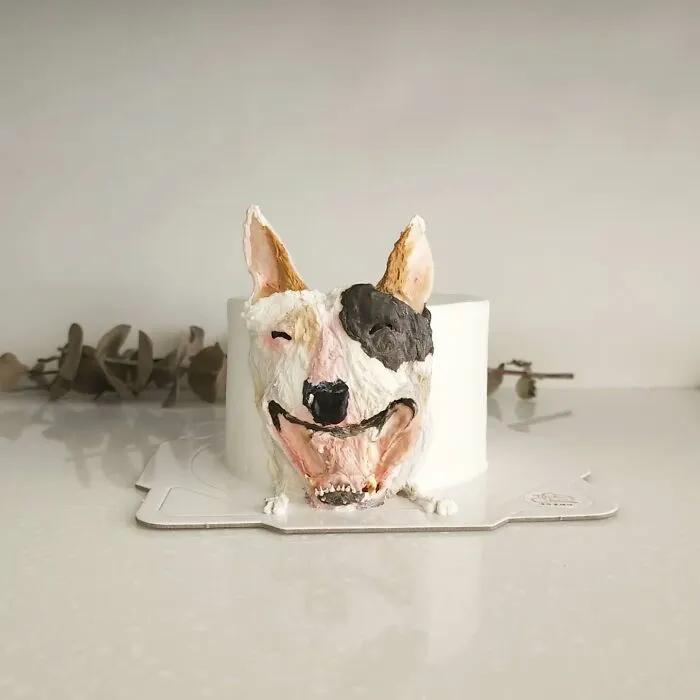 Pet-themed cake shaped like a smiling dog with detailed frosting capturing the pet's unique personality.