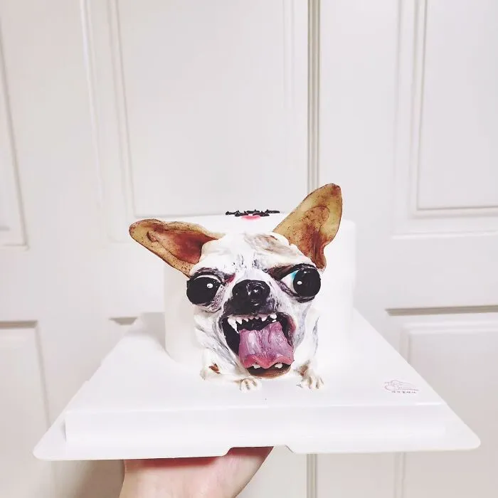 3D pet-themed cake of a dog with tongue out, showcasing artist's skill in creating adorable pet-themed cakes.