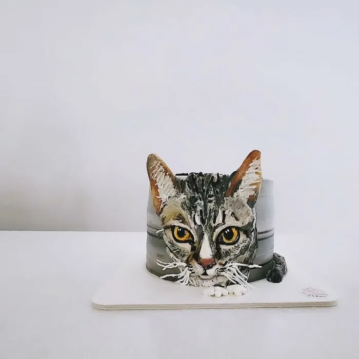 Pet-themed cake shaped and decorated as a realistic cat, showcasing adorable and unique artistic cake design.