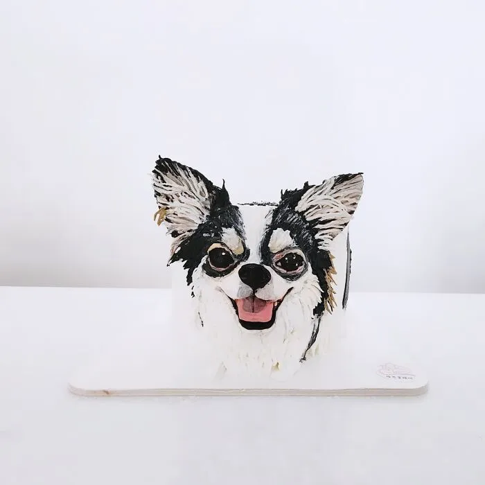 Cake shaped like a smiling dog with detailed fur, showcasing adorable pet-themed cake artistry capturing unique personality.