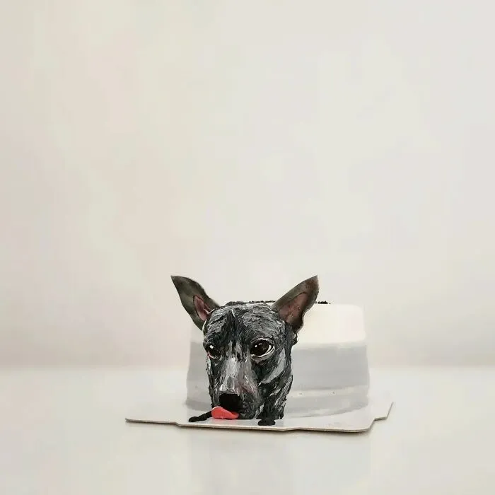 Black dog cake with detailed face and ears, an adorable pet-themed cake capturing unique personality.