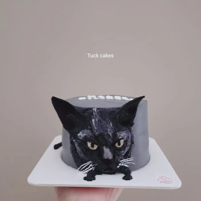 Pet-themed cake shaped like a black cat capturing unique personality with detailed facial features and realistic design.