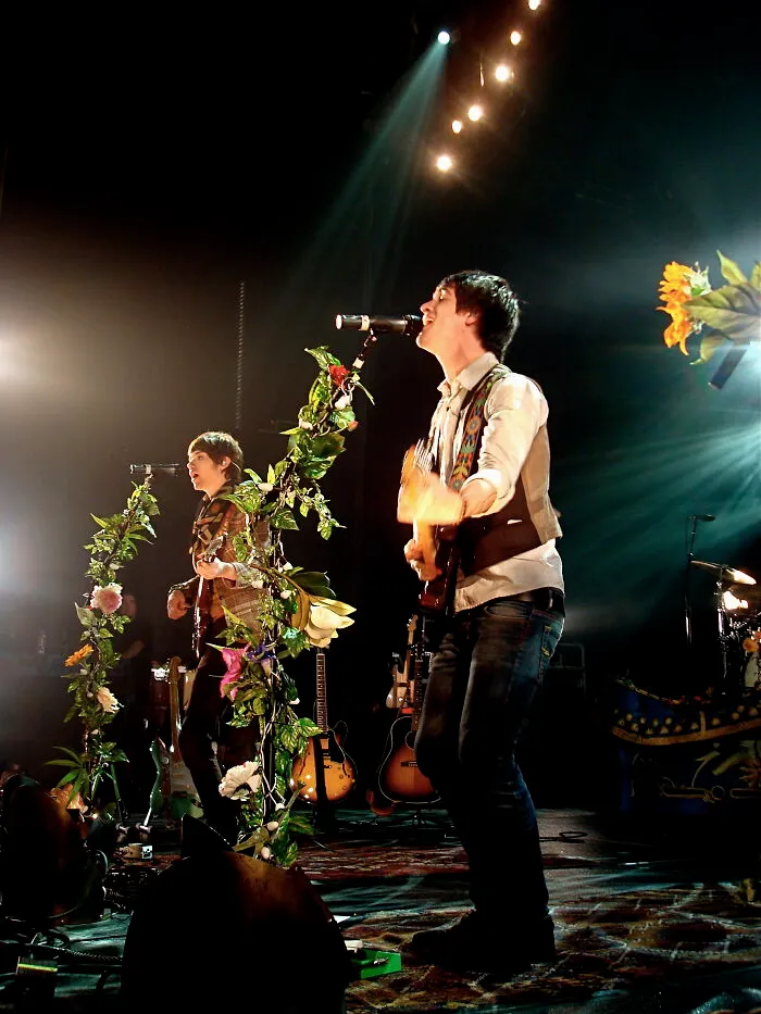 Musicians performing live on stage with floral-decorated microphones during memorable I was there moments.