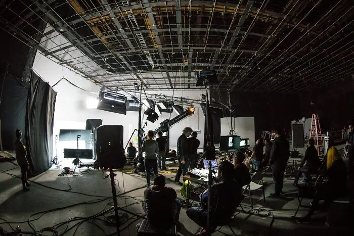Film crew working on a production set with cameras, lights, and crew capturing authentic I was there moments.