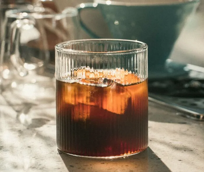 Glass of iced beverage on a marble table with blurred background, illustrating Americans reveal cultural habits.
