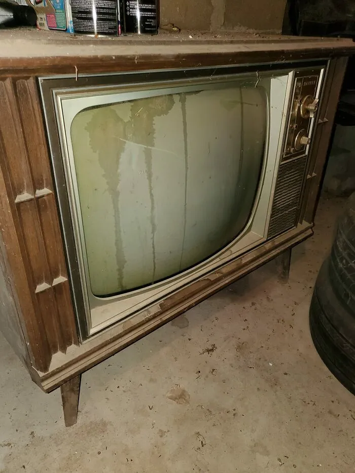 Vintage television found in hidden places of people’s homes with signs of age and dust in a basement setting.