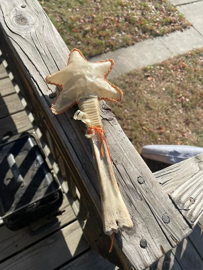 Handcrafted star-shaped wand made from bone and fabric, one of the unexpected things found in walls and hidden places at homes.