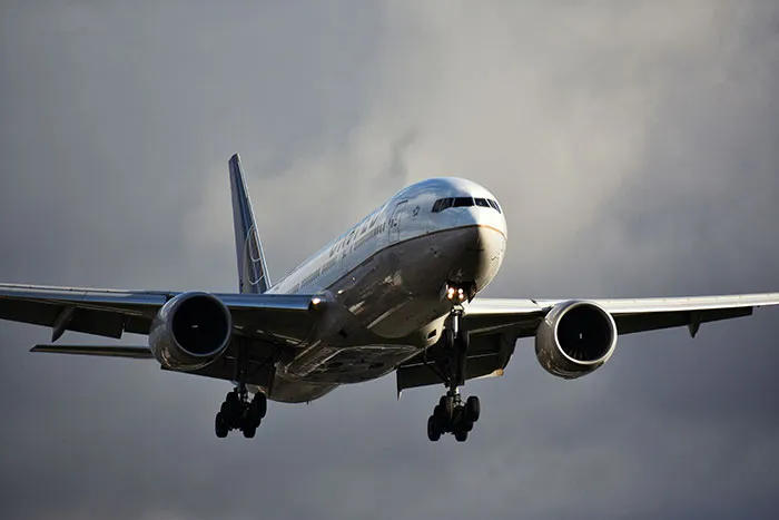 Commercial airplane flying low in cloudy sky, illustrating facts to keep the brain active and healthy.