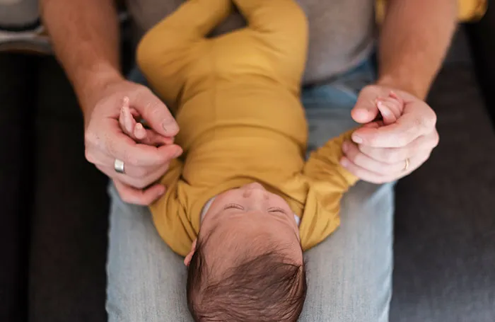 Healthcare worker gently holding a newborn baby dressed in yellow, highlighting moments that changed healthcare forever.