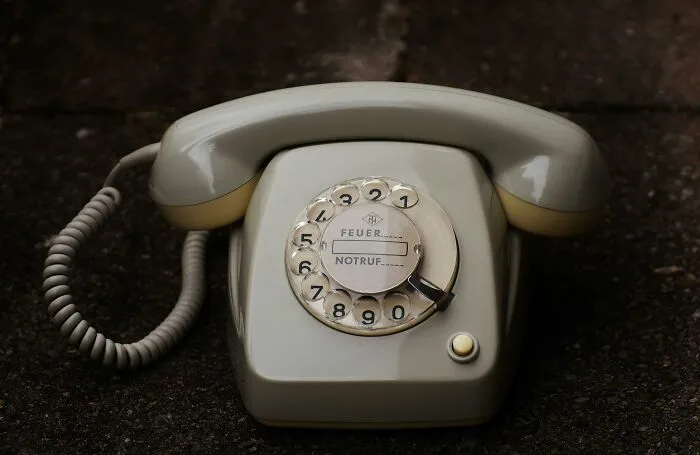 Vintage rotary phone on dark surface, representing obsolete skills people online needed before the 2000s but don’t need now.