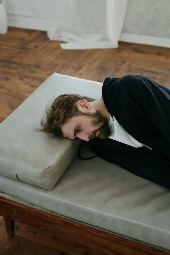 Man in black hoodie lying on a gray hospital bed cushion reflecting on insane hospital experiences and medical drama moments