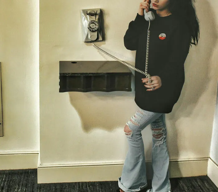Young woman using a vintage rotary phone, capturing the unique childhood joys that faded with smartphones.