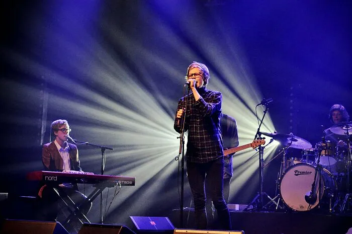 Band performing live on stage with dramatic lighting, illustrating professions that attract the most awful people.