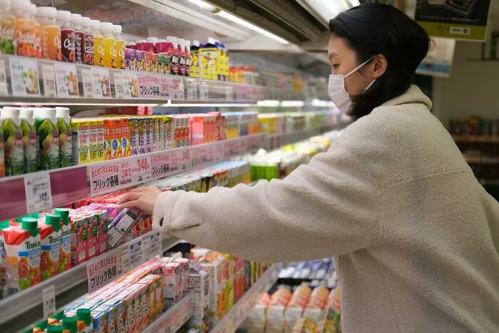 Woman wearing a mask shopping in a grocery store aisle, highlighting tobacco anything never habits discussed by oncologists.