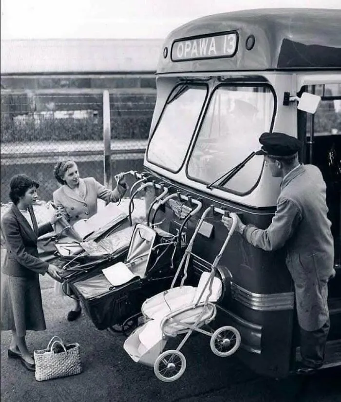 Mujeres suben cochecitos de bebé a un autobús antiguo, mostrando un lado distinto de la Historia en una foto histórica.