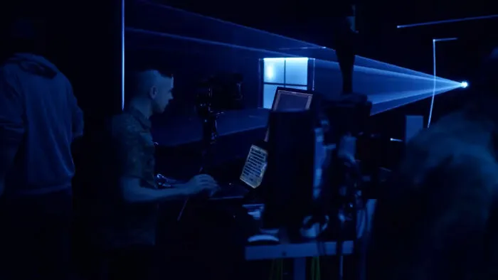 Persona trabajando con equipo audiovisual en un espacio oscuro, mostrando ángulos alternativos en eventos y lugares únicos.