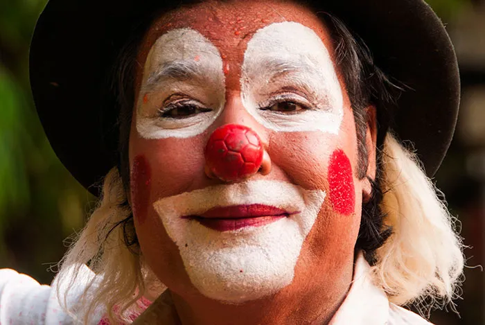 Close-up of a clown face with red nose and white makeup, illustrating kids lies that started silly and became real.