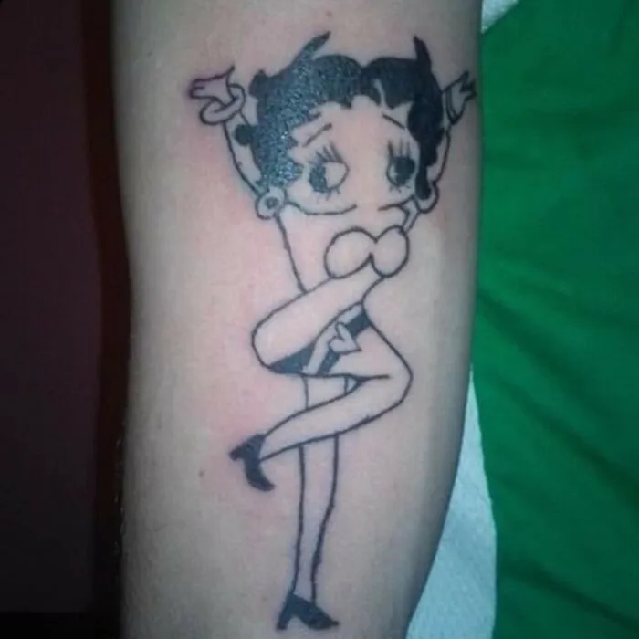 Tattoo of a distorted cartoon character on a forearm, showcasing one of the bizarre choices people made while getting tattoos.