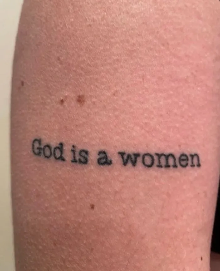 Tattoo on arm stating God is a women, showcasing bizarre choices people made while getting tattoos.