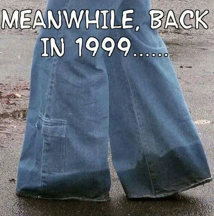 Baggy blue jeans soaked at the bottom standing on wet pavement, capturing the nostalgic magic of growing up in the ’90s.