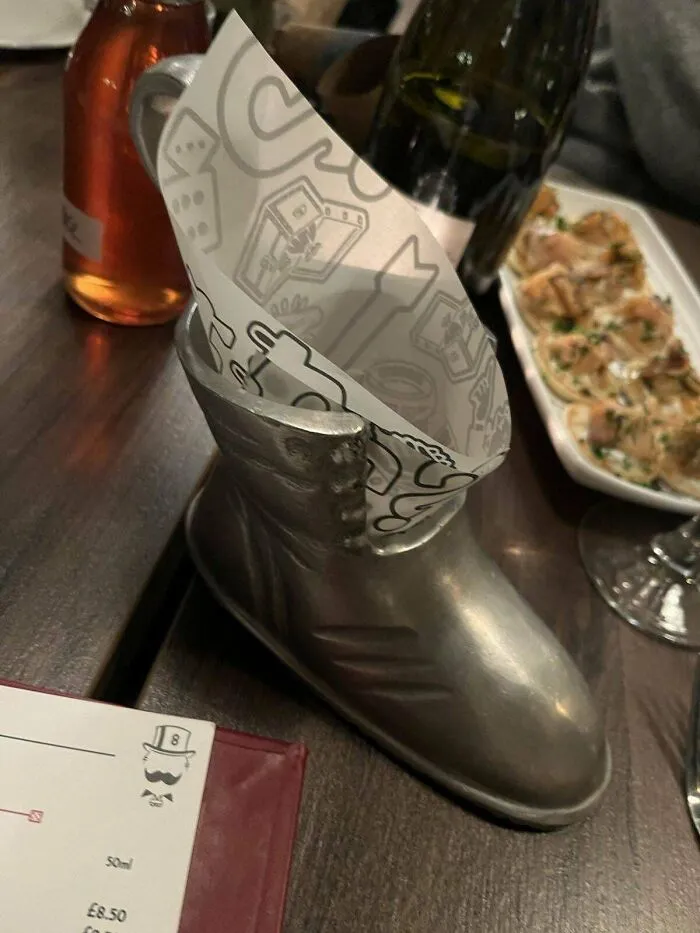 Metal shoe serving food with paper liner inside, part of unholy meal presentation and unusual food serving ideas.