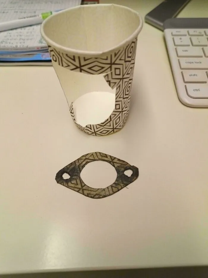 Paper cup with a cut-out section and a makeshift gasket made from the cup, showing redneck engineering creativity.