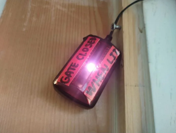 Remote control taped with red paper labeled gate closed, showing an example of redneck engineering creativity.