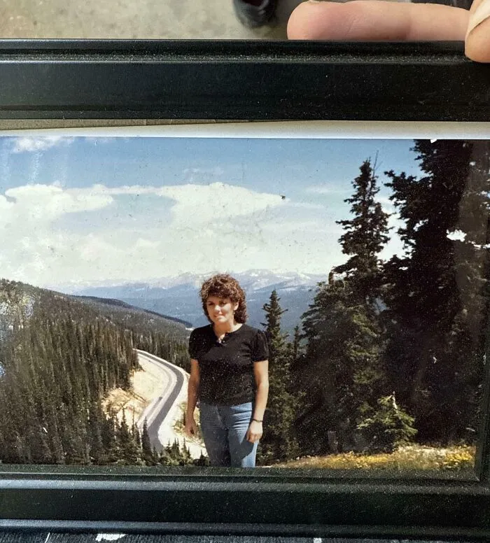 Person standing by a mountain road surrounded by trees, illustrating one of the most interesting mysteries that still baffle people.