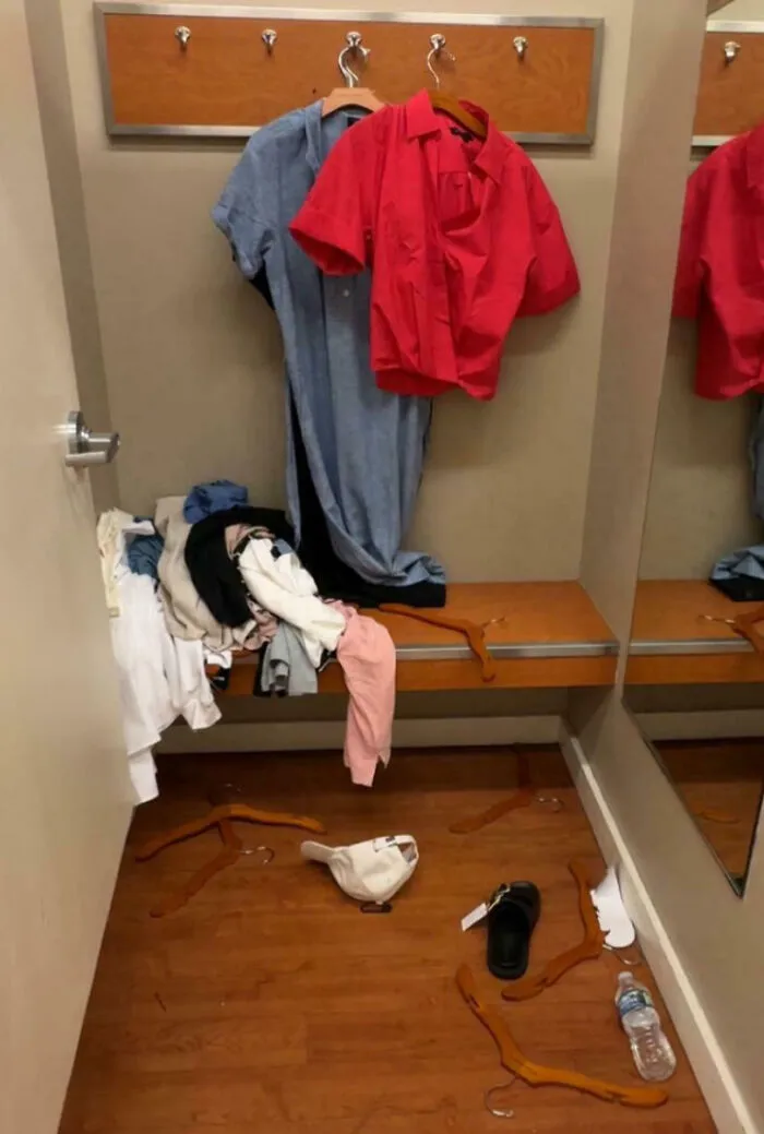 Vestidor desordenado con ropa y perchas tiradas, reflejando un mal día en el trabajo complicado y caótico.