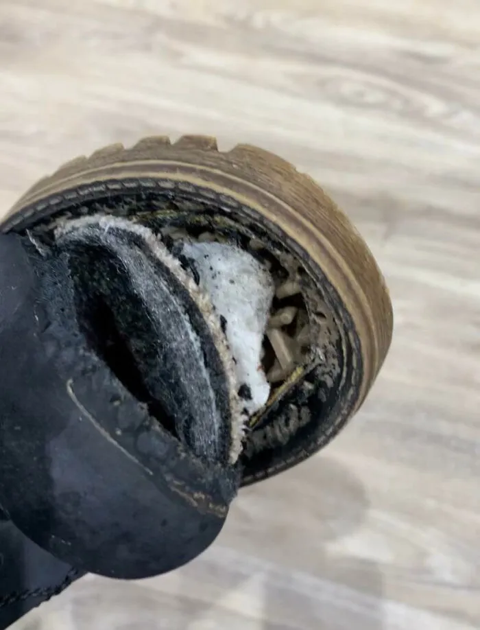 Bota de trabajo muy desgastada mostrando un día peor en el trabajo con daño y deterioro evidente.