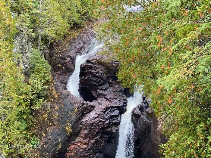Waterfall flowing through rocky terrain surrounded by lush greenery, representing interesting mysteries that still baffle people.