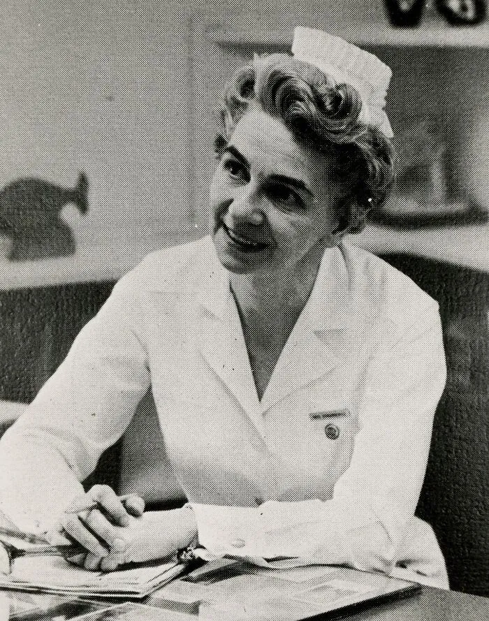 Vintage photo of a nurse in uniform smiling warmly, showcasing classic nursing style and compassionate care from past decades.