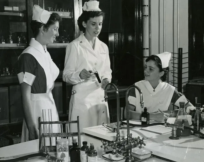 Three vintage nurses in uniform working together in a laboratory setting, showcasing healing and hope.